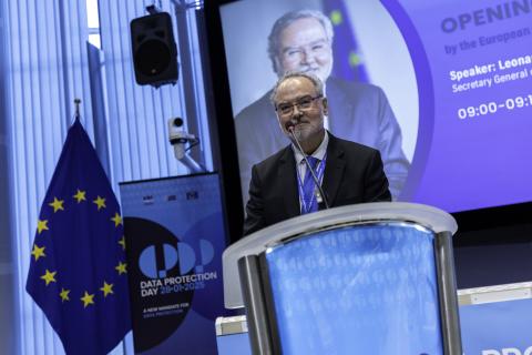 Leonardo Cervera-Navas speaking behind the microphone and a blue EU flag behind